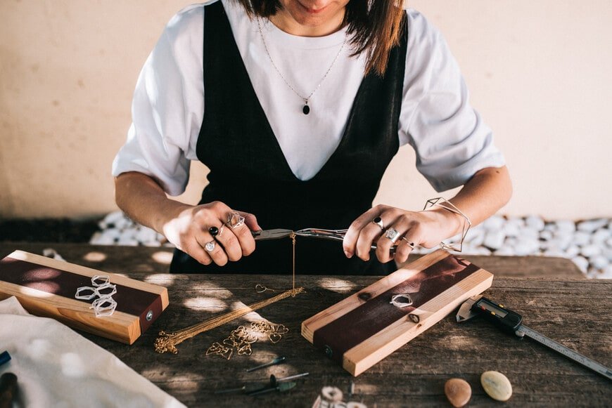 Mujer trabajando en la creación de joyería artesanal.