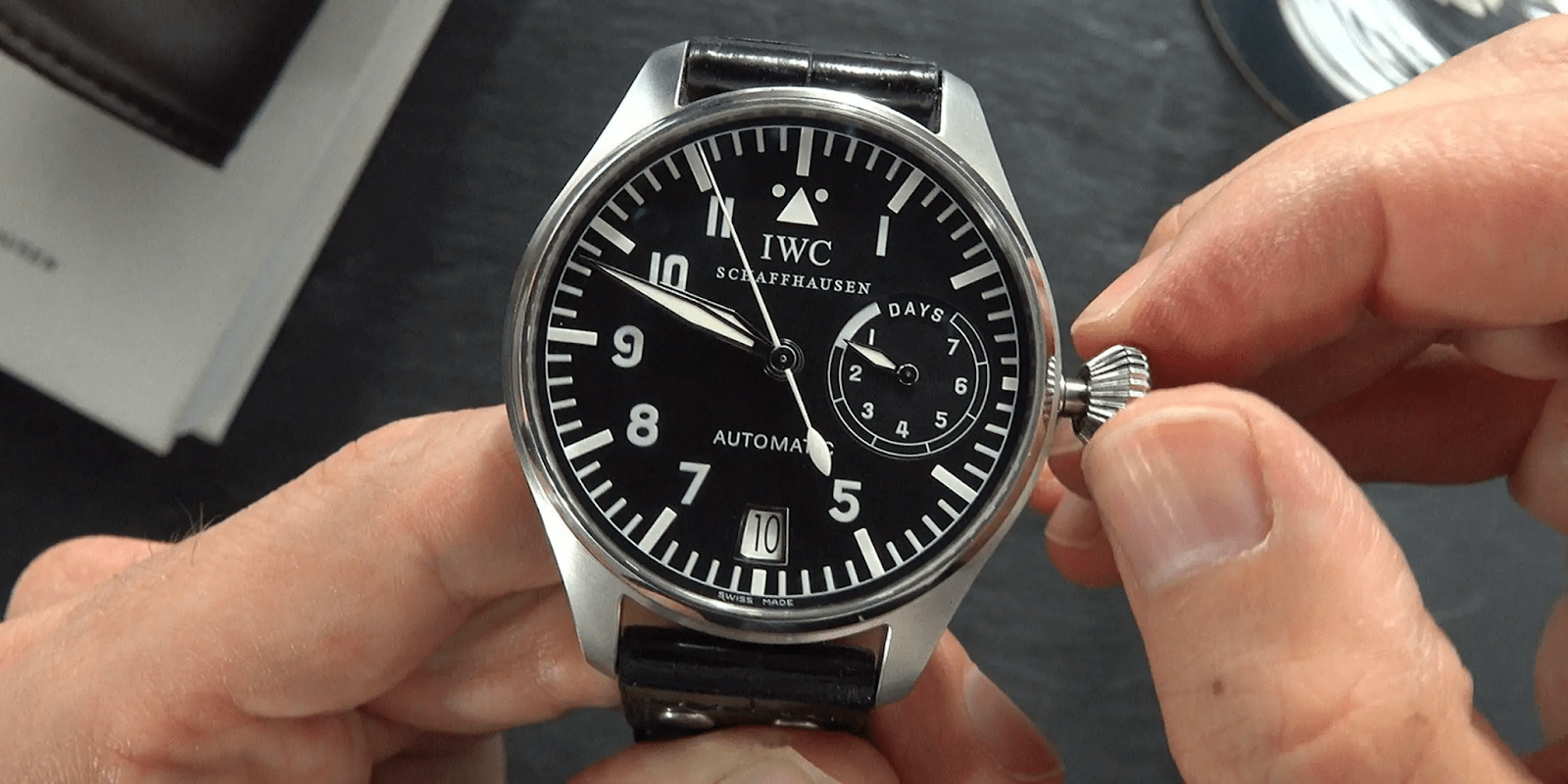 persona sosteniendo un reloj IWC color plateado